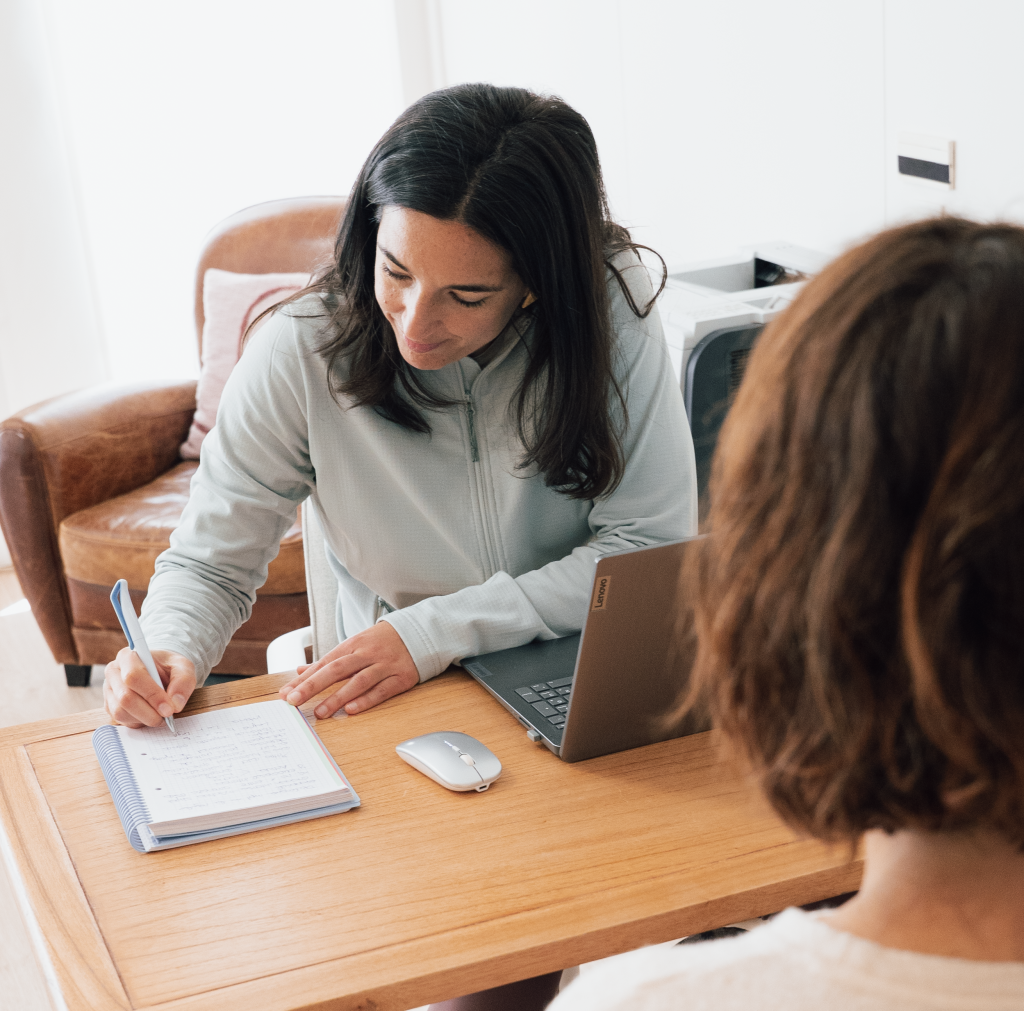 historia clinica consulta personalizada amaia cano donostia - Osteopatía y Fisioterapia Amaia Cano completando la historia clínica de una paciente durante una consulta personalizada en Donostia - San Sebastián.